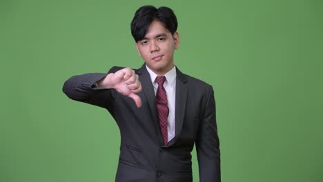 Young-handsome-Asian-businessman-giving-thumbs-down