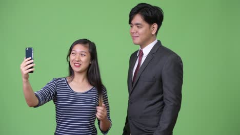 Young-handsome-Asian-businessman-and-young-Asian-woman-working-together