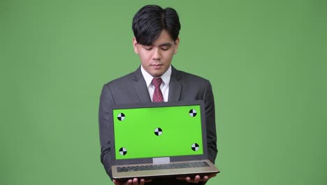 Young-handsome-Asian-businessman-showing-laptop