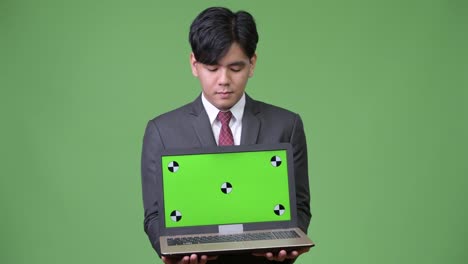 Schöne-asiatische-Jungunternehmer-zeigen-laptop