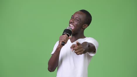 Young-happy-African-man-smiling-while-speaking-on-microphone