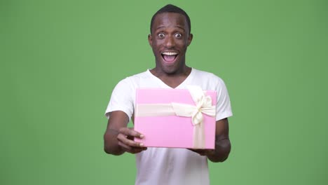 Joven-hombre-feliz-mirando-sorprendido-al-abrir-la-caja-de-regalo