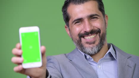 Handsome-Persian-bearded-businessman-showing-phone