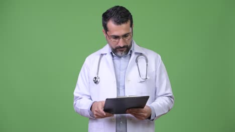 Gut-aussehend-persischen-bärtigen-Mann-Arzt-lesen-Zwischenablage