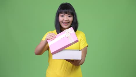 Schöne-glückliche-asiatische-Frau-Geschenk-Box-öffnen