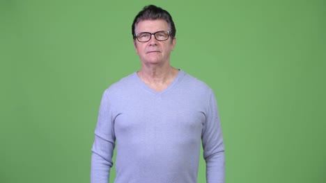 Senior-handsome-man-with-eyeglasses-against-green-background