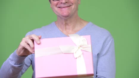 Senior-handsome-man-holding-gift-box