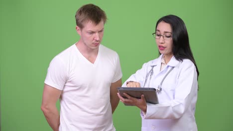 Young-Asian-woman-doctor-giving-consultation-to-young-man-patient