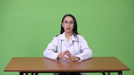 Young-beautiful-Asian-woman-doctor-talking-to-camera