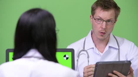 Young-Asian-woman-doctor-having-meeting-with-young-man-doctor