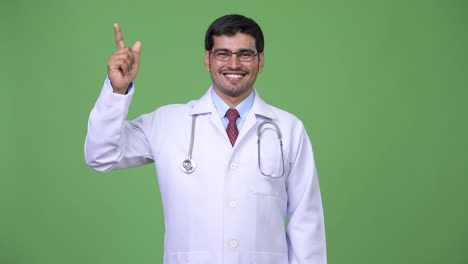 Young-handsome-Persian-man-doctor-pointing-up