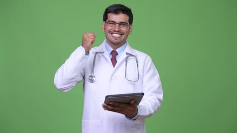 Young-handsome-Persian-man-doctor-using-digital-tablet
