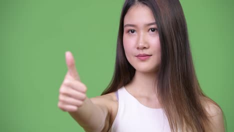 Young-beautiful-Asian-businesswoman-giving-thumbs-up