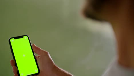 Young-adult-man-using-smartphone-with-green-screen-during-fitness-sport-workout-.Grunge-industrial-urban-training.4k-slow-motion-video