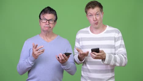 Senior-handsome-man-and-young-handsome-man-using-phone-together