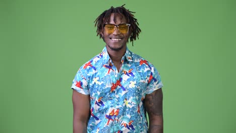 Hombre-joven-turista-africano-guapo-feliz-sonriendo-mientras-se-está-usando-gafas-de-sol