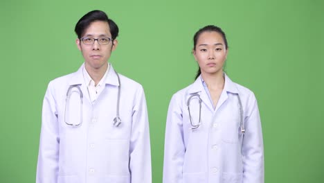 Young-Asian-couple-doctors-with-stop-gesture-together