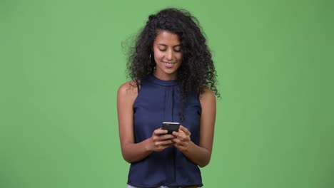 Young-beautiful-Hispanic-businesswoman-thinking-while-using-phone