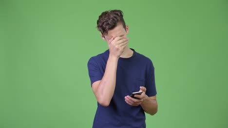 Young-teenage-boy-using-phone-and-getting-bad-news