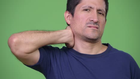 Betonte-Hispanic-Mann-mit-Nackenschmerzen