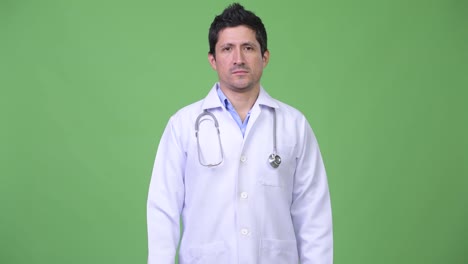 Médico-hombre-hispano-sobre-fondo-verde