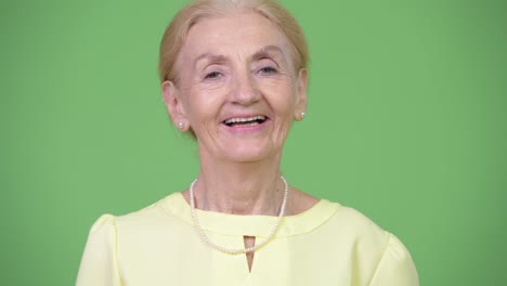 Studio-shot-of-happy-senior-businesswoman-with-blond-hair