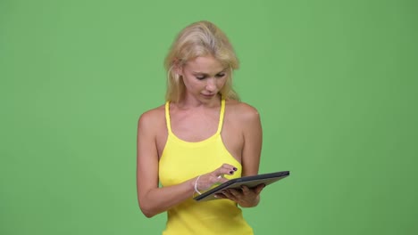 Young-happy-beautiful-blonde-woman-using-digital-tablet