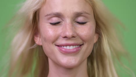 Head-shot-of-happy-young-beautiful-blonde-woman-feeling-the-fresh-air-with-eyes-closed