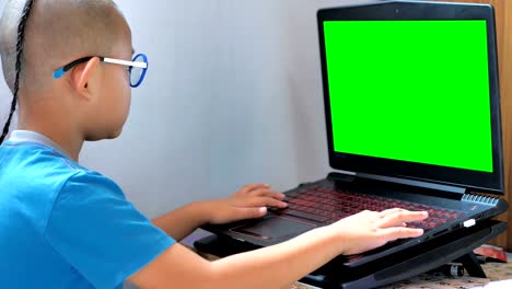 Asiaten-Knabe-Laptop-Computer-und-green-Screen-spielen.-Glückliche-Kinder-spielen-Computer-zu-Hause-genießen.