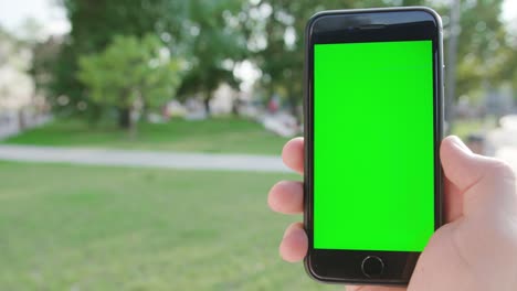 Eine-Hand-hält-eine-Telefon-mit-einem-Green-Screen