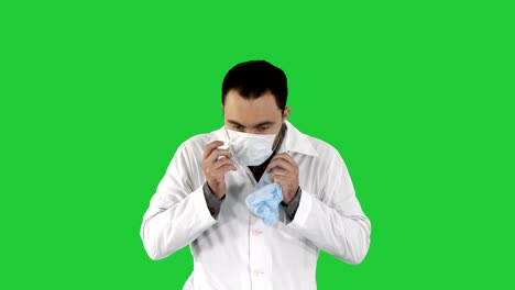 Portrait-of-medical-doctor-putting-mask-and-hat-on-on-a-Green-Screen,-Chroma-Key