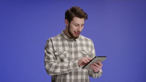 Confident-man-working-on-tablet-and-smiling