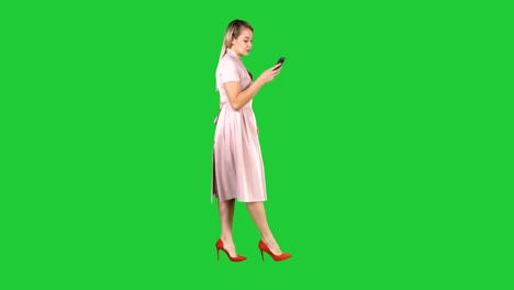 Mujer-bonita-rubia-mediante-mensaje-de-texto-de-teléfono-celular-en-una-pantalla-verde-Chroma-Key