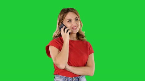Junge-schöne-Frau-im-roten-T-shirt-spricht-über-Handy-auf-einem-Green-Screen,-Chroma-Key