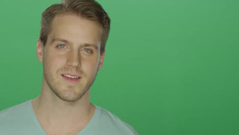 Junger-Mann-lächelt-charmant,-auf-einem-green-Screen-Studio-Hintergrund