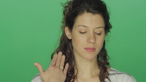 Young-woman-starting-to-feel-better-after-crying,-on-a-green-screen-studio-background