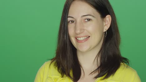 Junge-Brünette-Frau-Lächeln-und-Lachen-auf-einem-green-Screen-Studio-Hintergrund