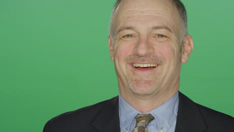 Middle-aged-businessman-smiling,-on-a-green-screen-studio-background