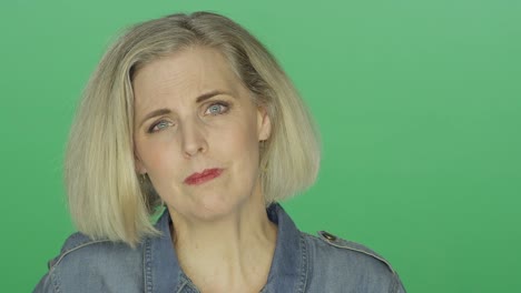 Beautiful-older-woman-looking-worried,-on-a-green-screen-studio-background