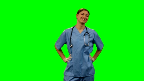 Happy-female-surgeon-standing-against-green-screen