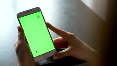 Mujer-joven-usa-smartphone-con-pantalla-verde-para-la-comunicación