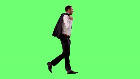 Junger-erfolgreicher-Geschäftsmann-im-Anzug-genießt-Schönwetter-wirft-Jacke-über-die-Schulter-während-des-Gehens.-Schuss-auf-Mock-up-Green-Screen.