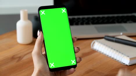 Person-using-cellphone-with-greenscreen-display-in-hand