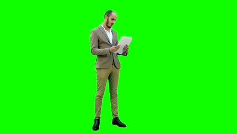 Junger-Geschäftsmann-aufmerksam-studieren-Dokumente-auf-einem-Green-Screen,-Chroma-Key