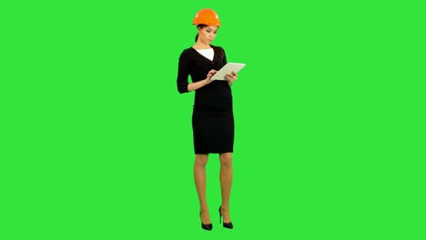 Mujer-arquitecto-en-casco-sosteniendo-la-tableta-y-hacer-inspección-sobre-una-pantalla-verde-Chroma-Key