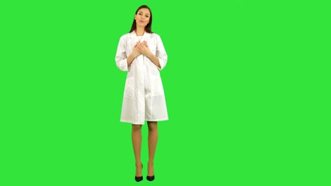 Schöne-Frau-im-Gespräch-mit-der-Kamera-auf-einem-Green-Screen,-Chroma-Key-Laborkittel-lächelnd