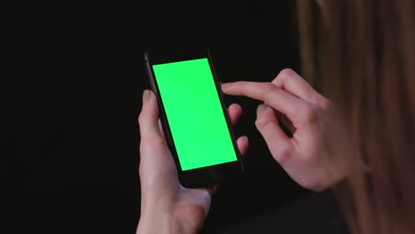 Woman-is-Holding-Phone-with-green-Screen-Tap