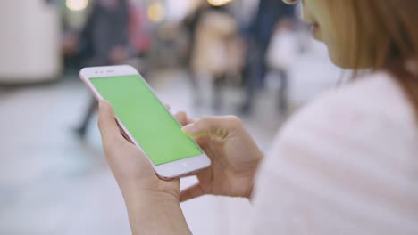 Mujer-con-smartphone-con-pantalla-verde-en-la-calle.