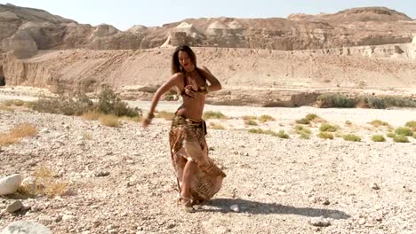 Beautiful-female-dancer.-Belly-dance.-Desert.-Sexy-golden-brown-dress-dancing.-Long-shot-up.