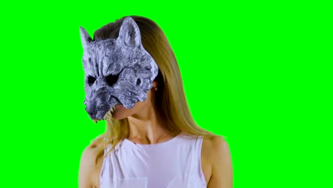 Happy-girl-wearing-wolf-mask-dances-at-green-background-and-shows-thumbs-up
